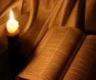 İncil ve sunak üzerinde yanan bir mum